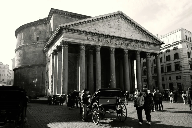 black and white pograph of horse and carriages at roman building