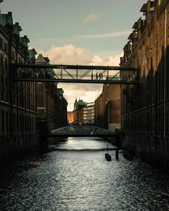 a bridge over the water with some people walking over it