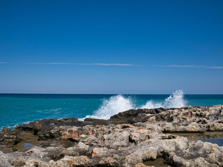 waves crash on the rocky shoreline of the ocean