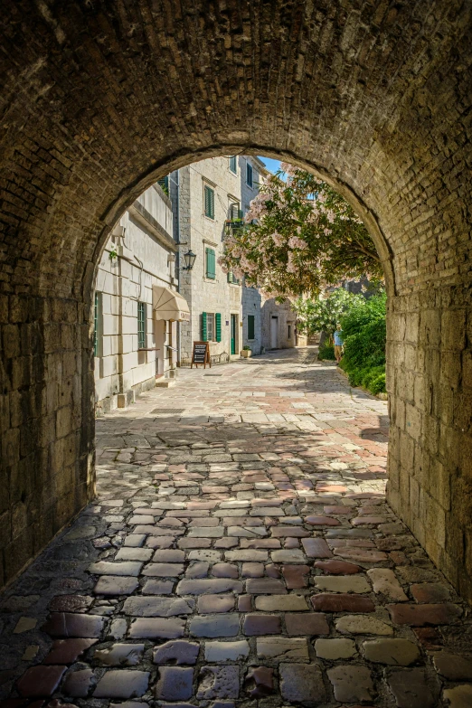 the road through a stone arch is shown