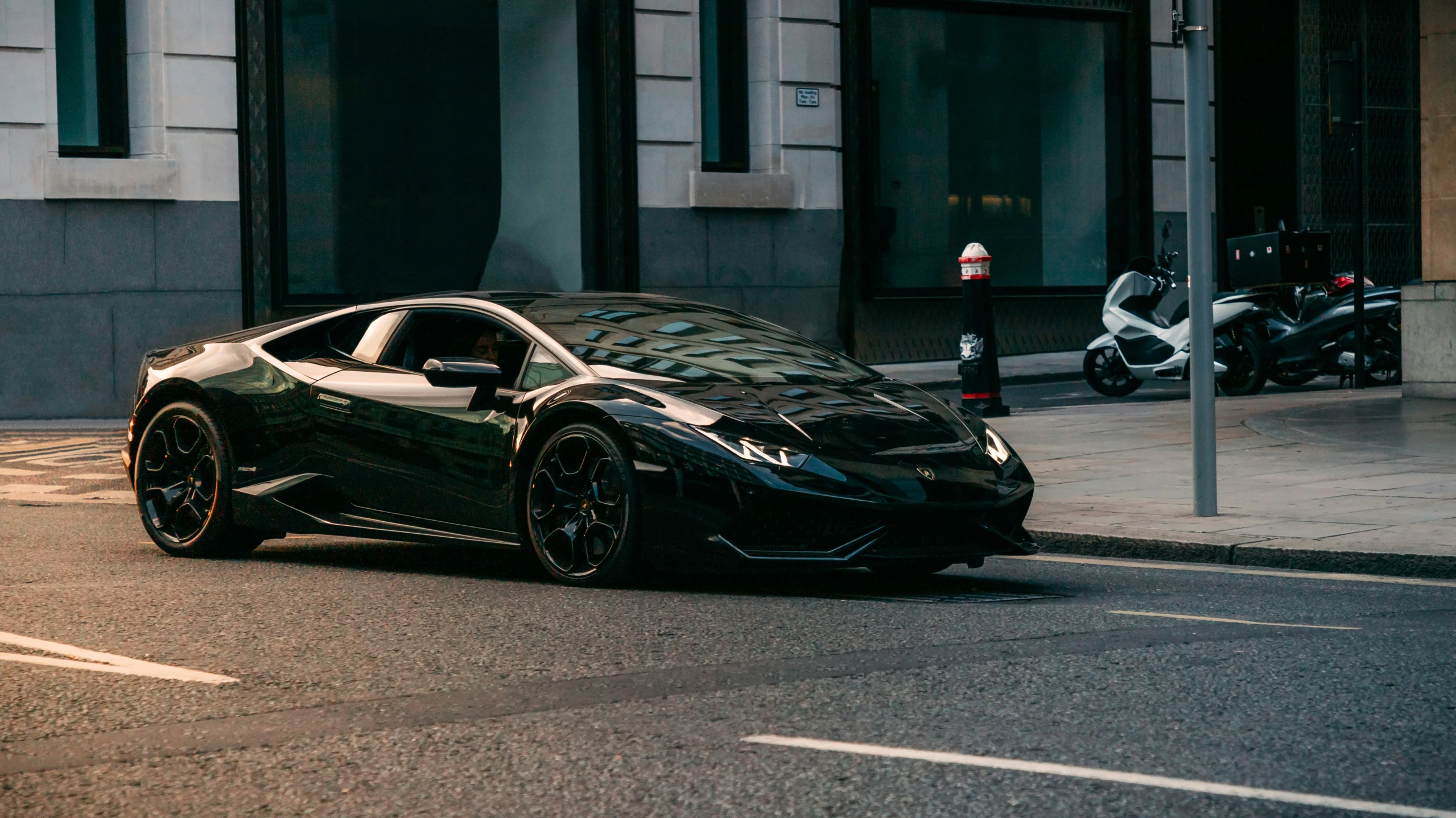 a black sports car is parked on the side of the street