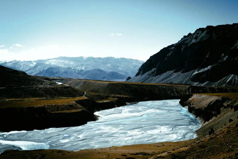 a small stream of water running between two rocky mountains