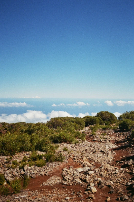 view from the top of a steep mountain overlooking clouds and sky