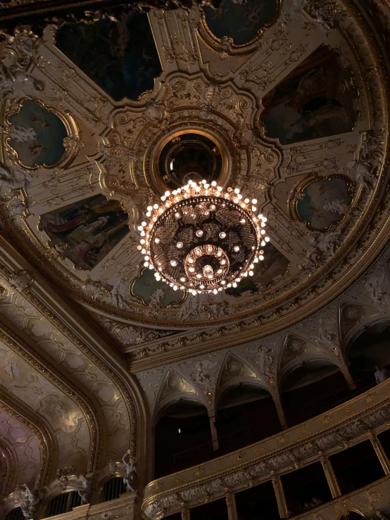 a chandelier hangs from the ceiling in an ornately decorated building