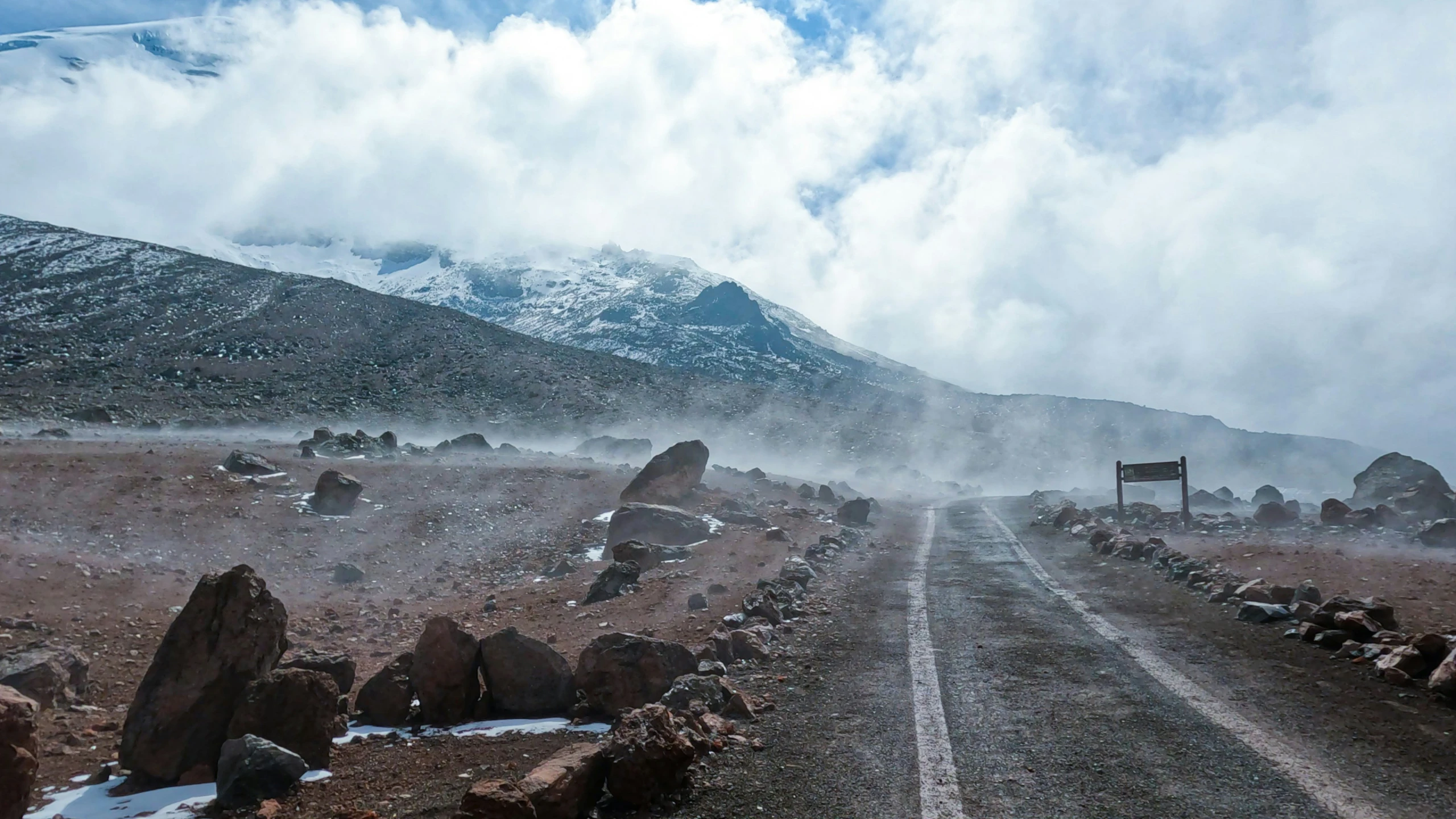 a dirt road surrounded by rocks and snow