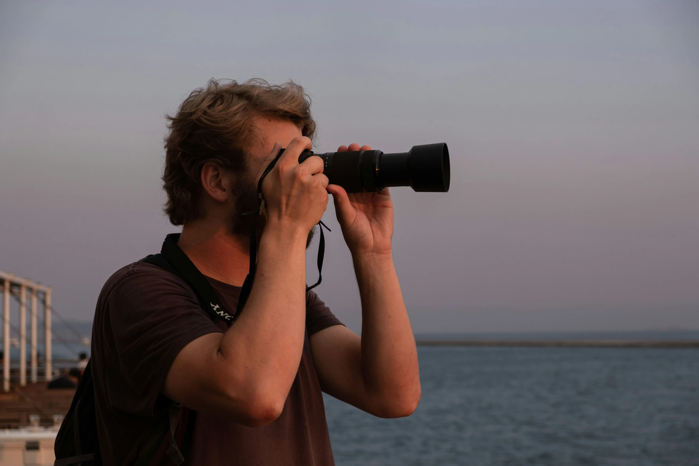 a man looking through the lens of his camera on the deck