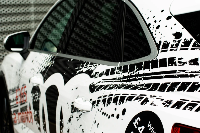 a white sports car painted with black and white images