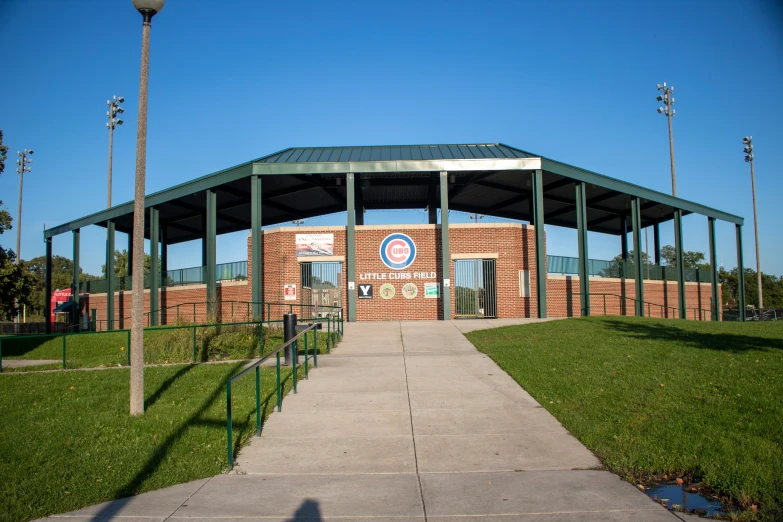 a brick shelter with grass and trees surrounding