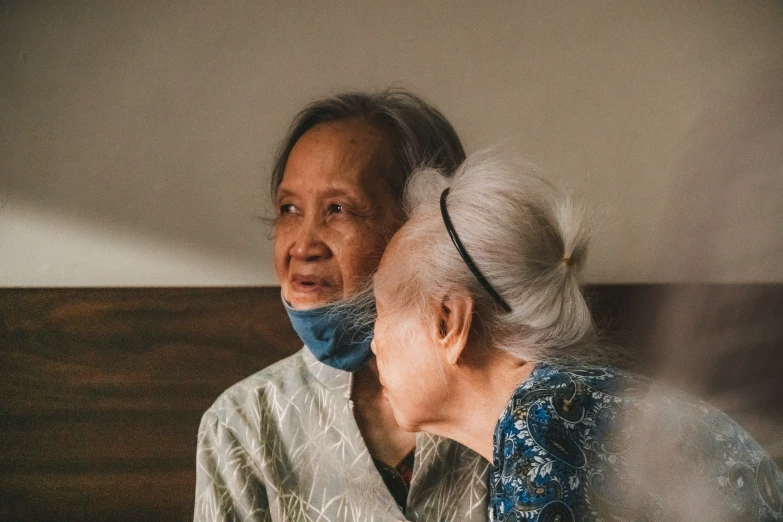 an older woman is listening to an elderly man