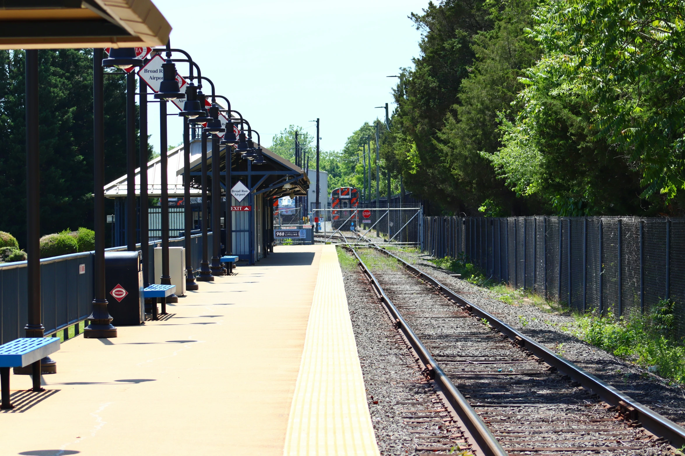 a train track is parallel and empty with a train station