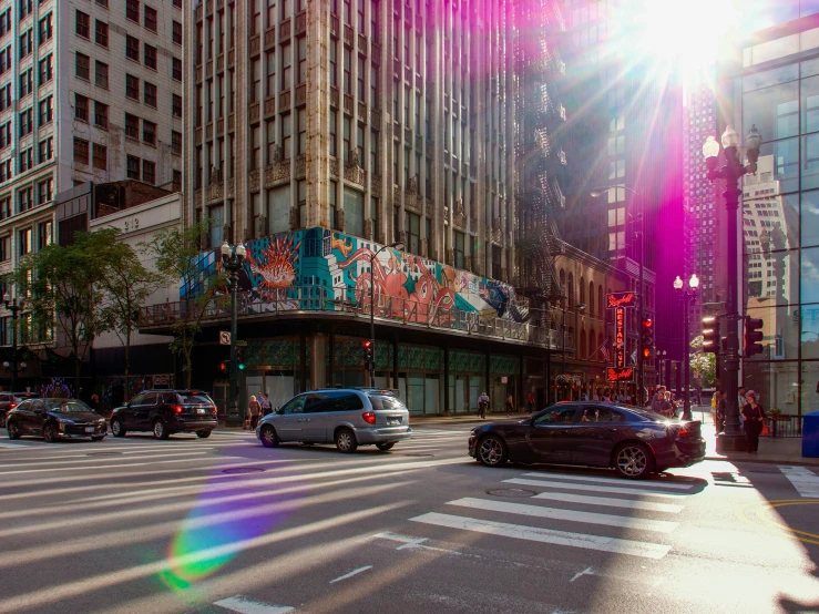 a street with parked cars on both sides and a tall building at the side