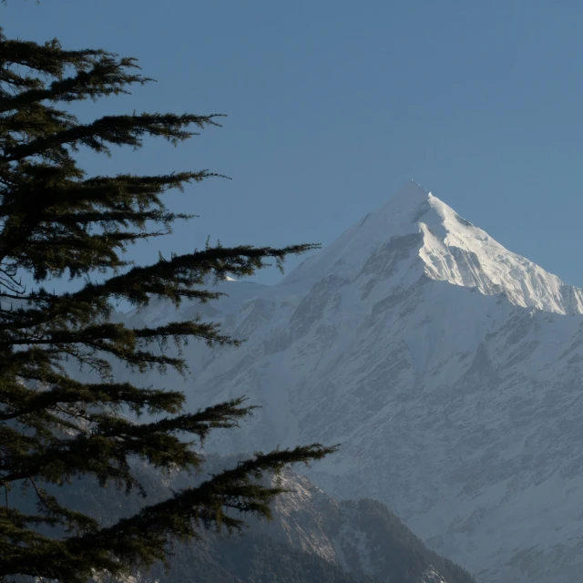 a very tall white snowy mountain peak on a sunny day