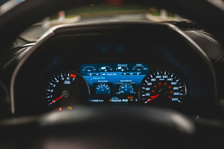 car dashboard with gauges and lights on in front of it