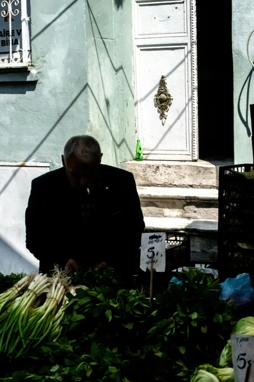 a man sitting by some baskets at a farmers market