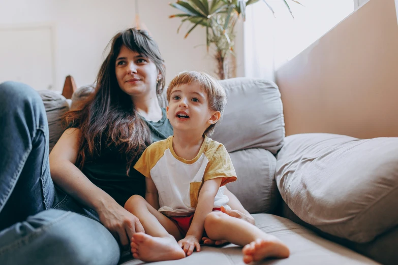 a mother and child sit on a couch