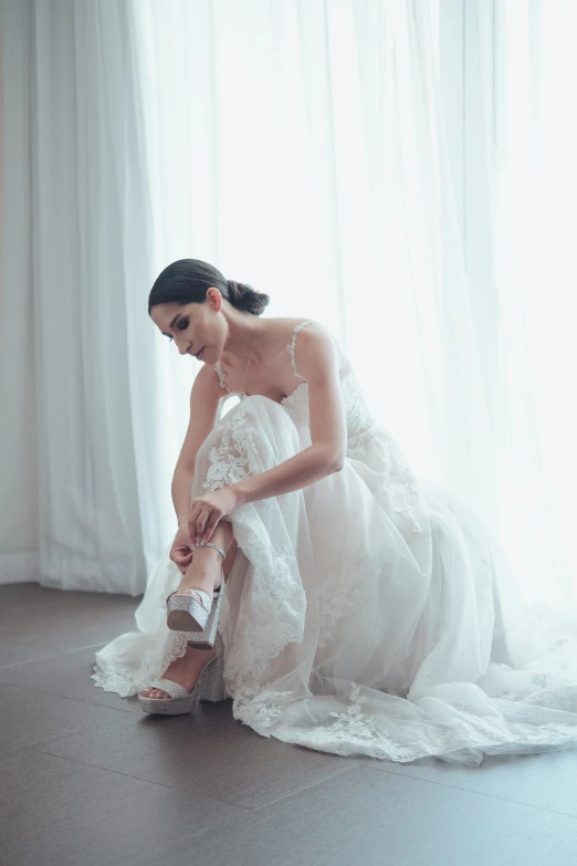 a woman is kneeling down by a curtain