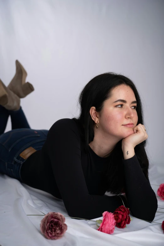 a woman lying on top of a bed of roses