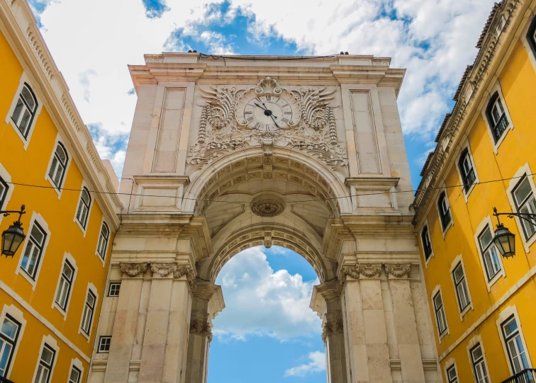 an ornate archway is flanked by a tall building