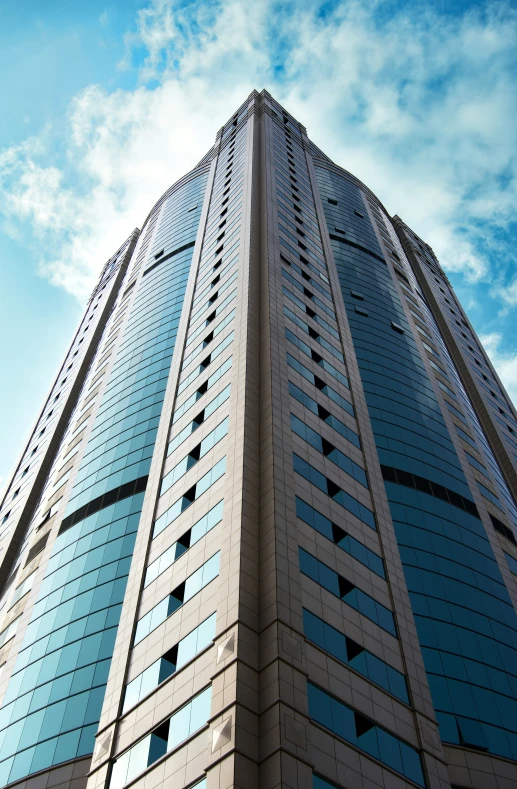 a very tall glass building with a sky in the background