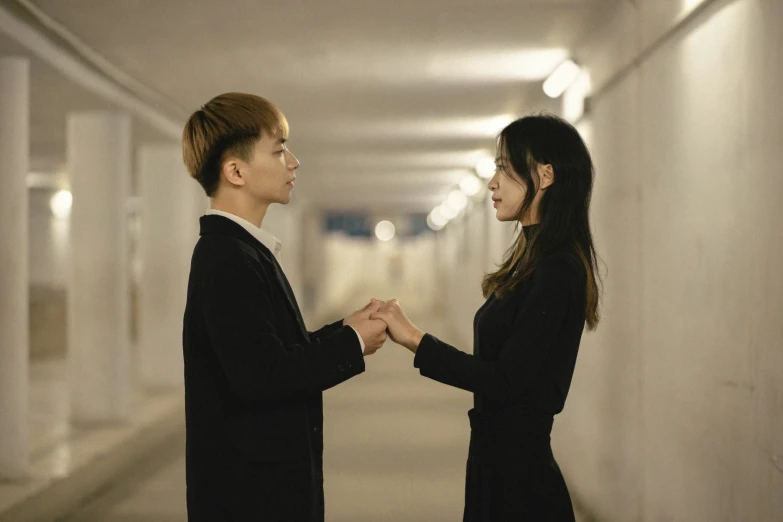 the couple is standing in an empty hallway, making faces to each other