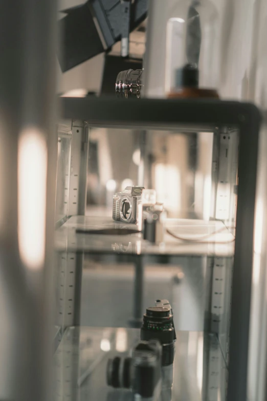 several cameras sit in a storefront as they look out from inside a case