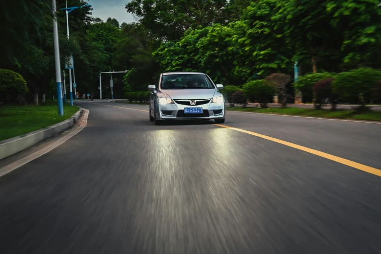 a small car is driving on a paved street