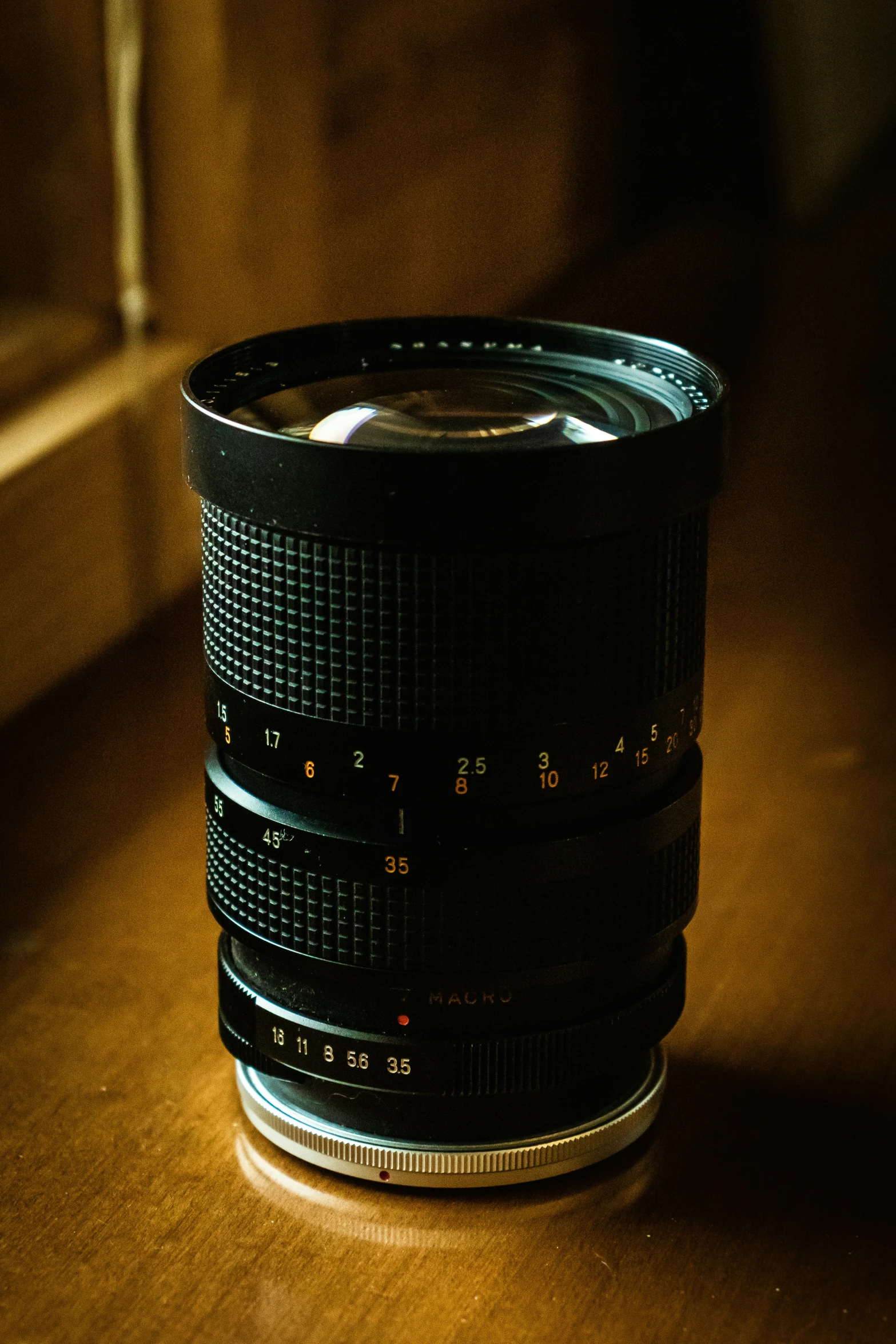 a very dark lens on a table near the window