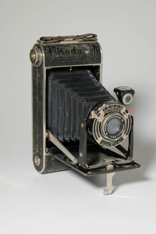 an old style camera is placed on top of a stand
