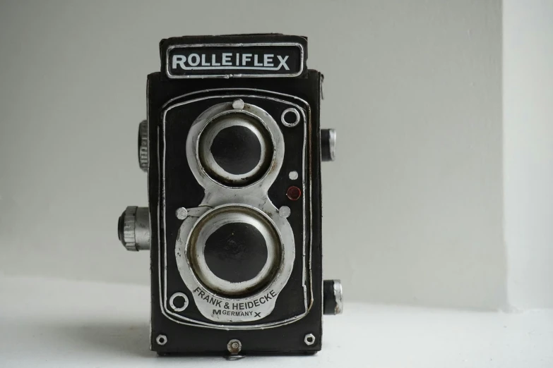 an old camera mounted on a white wall