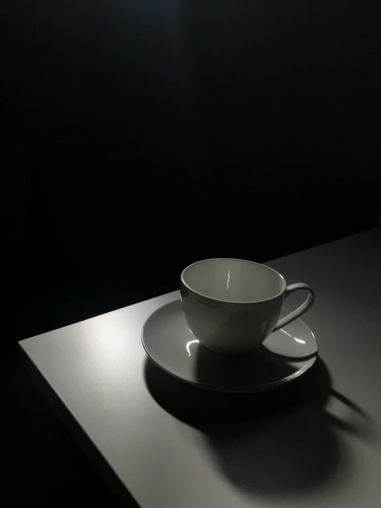 white porcelain teacup with saucer on top sitting upon table