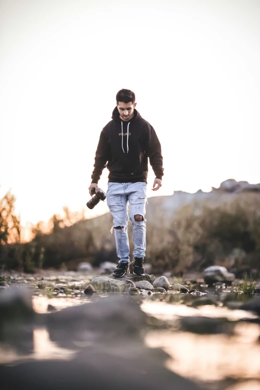 a man walking on a road holding a camera