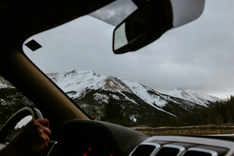 a dashboard s taken from inside the vehicle, showing the view of the mountains behind them