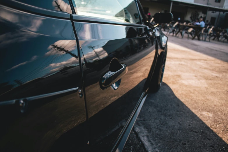 an old black car parked on the side of a street