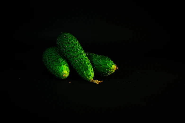 a pair of pickles are on a black surface