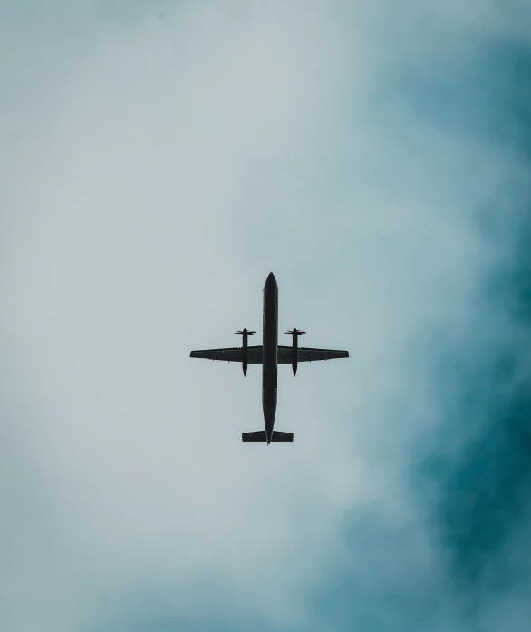 an airplane is flying against a cloudy blue sky