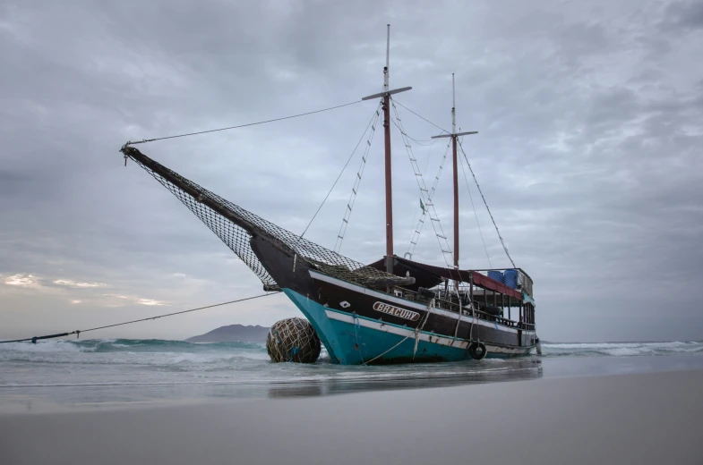 an old fishing boat is sitting on the sand