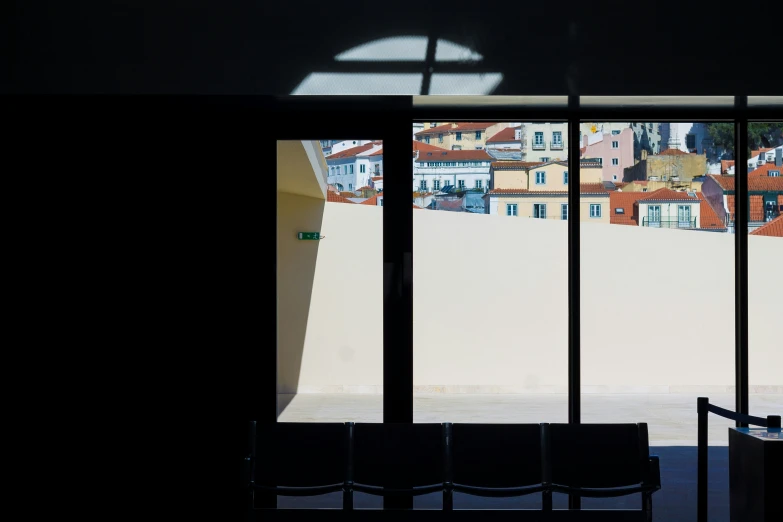 three empty chairs are against a city skyline as seen through large windows