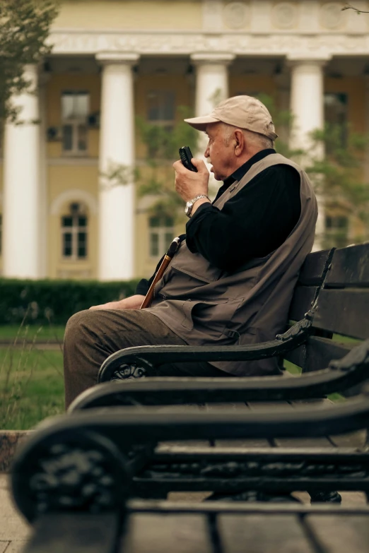 a man sitting on top of a bench holding a phone