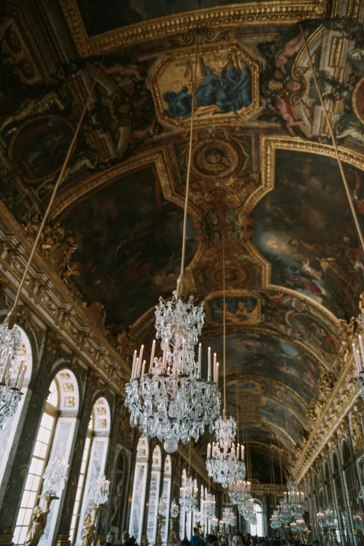 chandelier hanging from an elaborate ceiling inside a palace