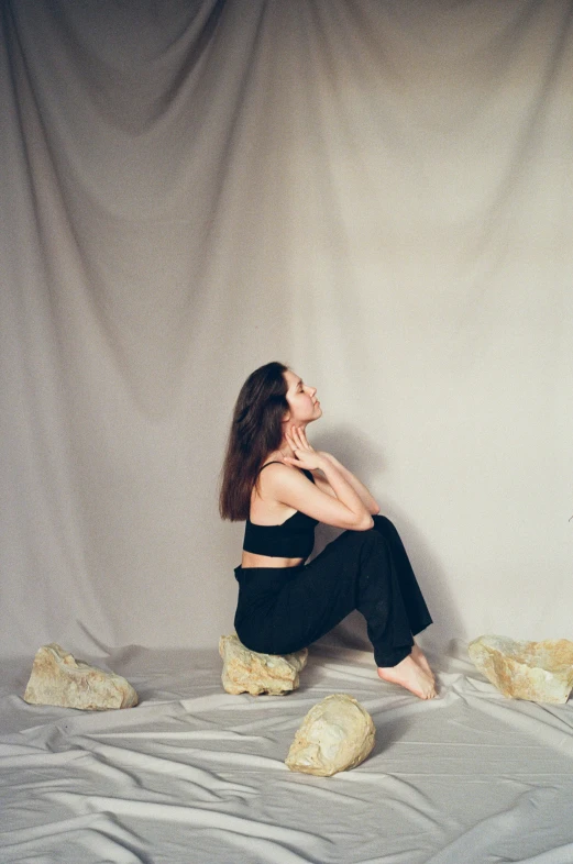 there is a woman posing next to some rocks