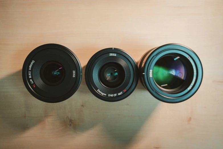 three camera lenses are sitting in a row