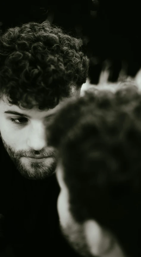 a man who has curly hair and is looking at soing