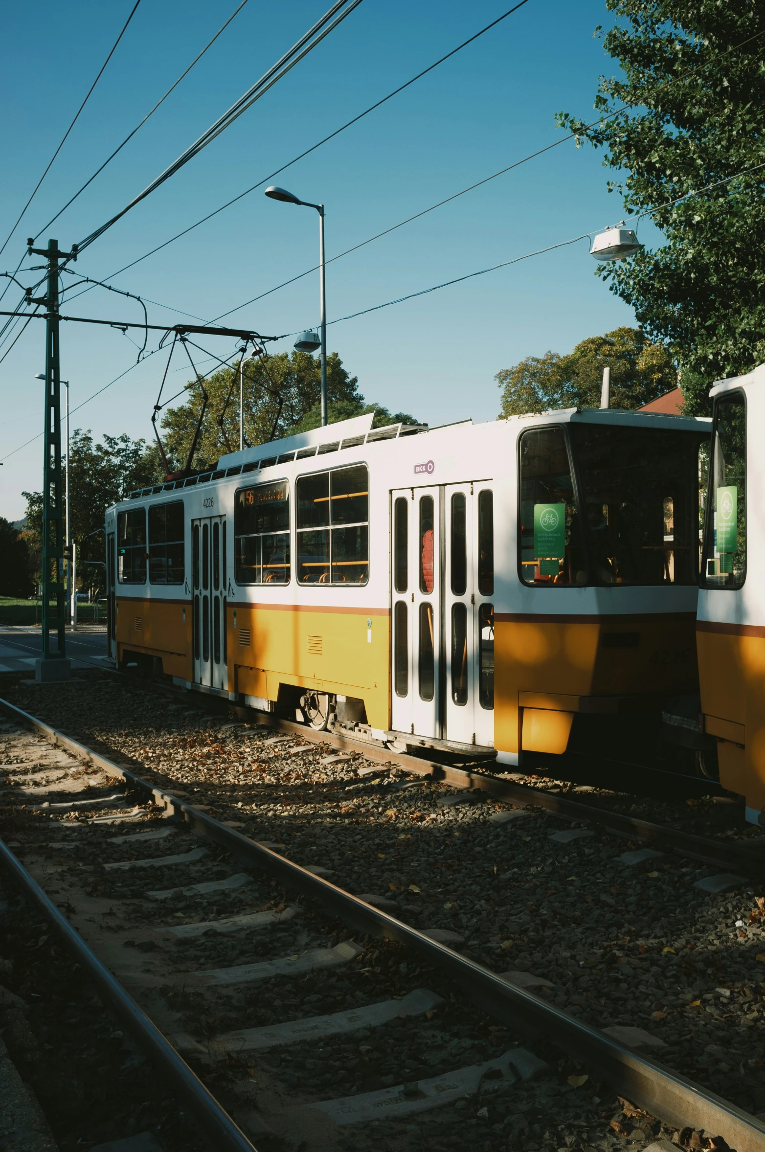 two small white and yellow trains sitting on the train tracks