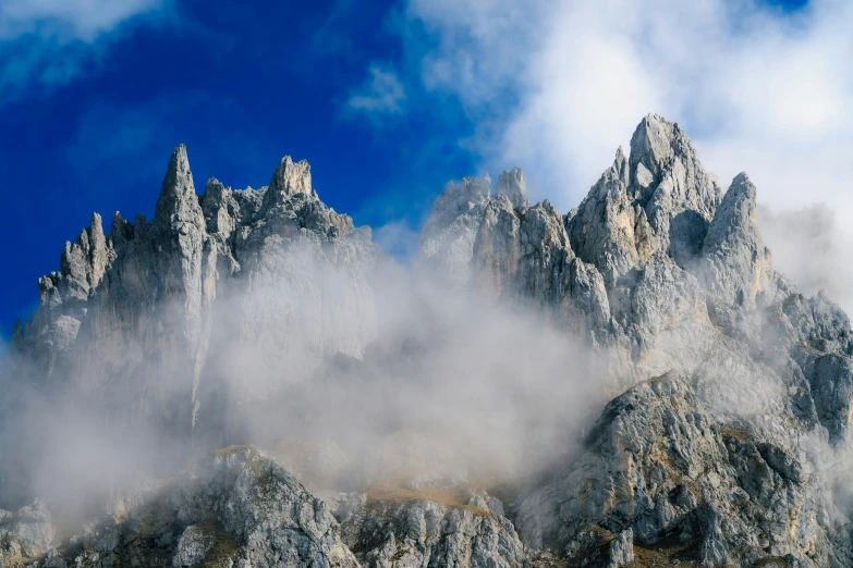 the top of a rocky mountain in the mountains covered with clouds