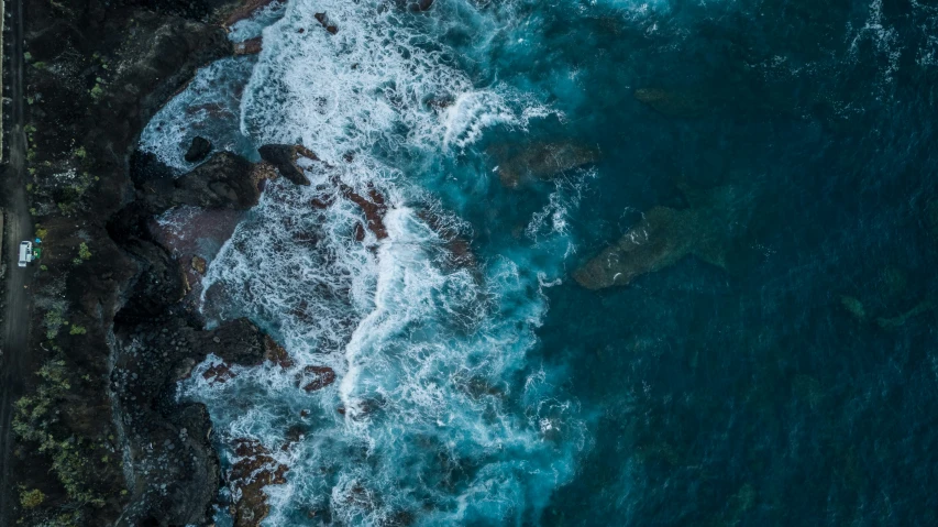 an aerial s of the ocean with a boat in the water