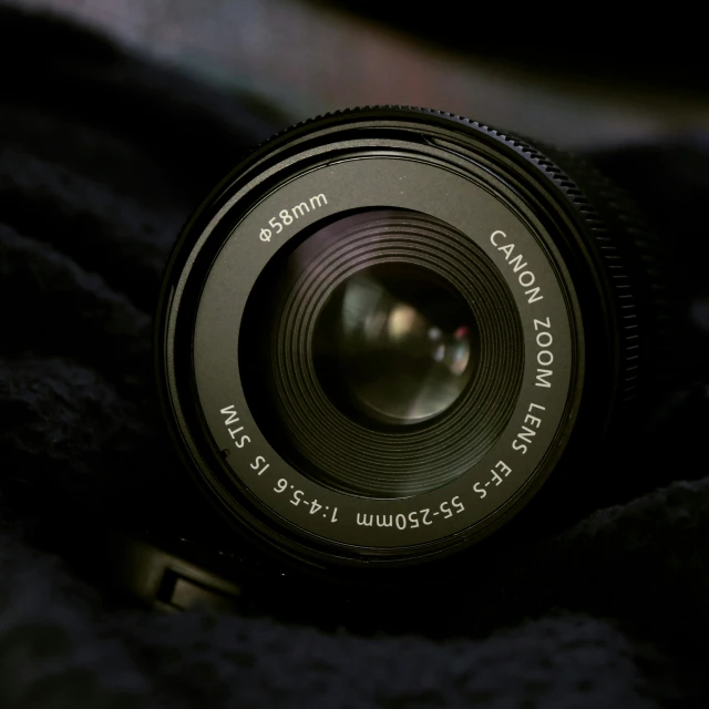 a camera lens sitting on top of a black blanket