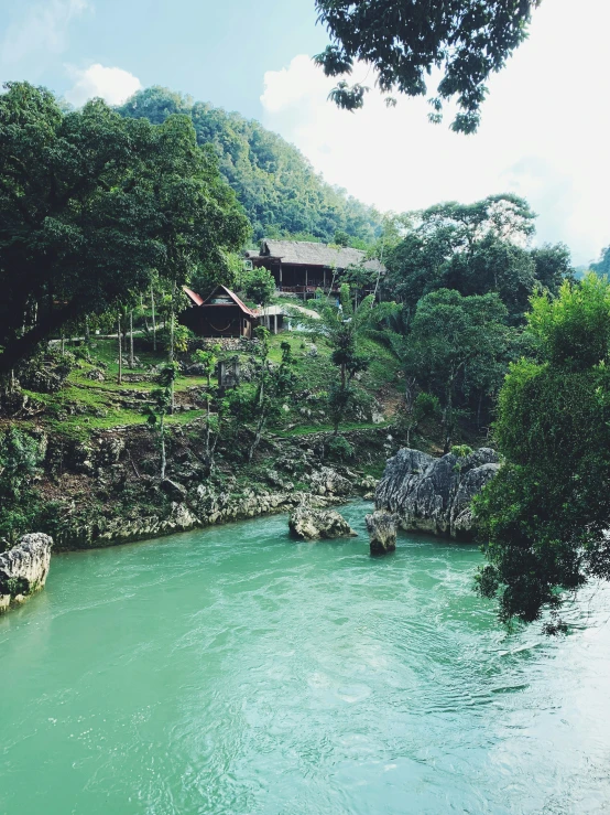 a house near the water with some rocks on the shoreline