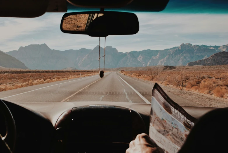 the inside view of a car shows the desert and mountains