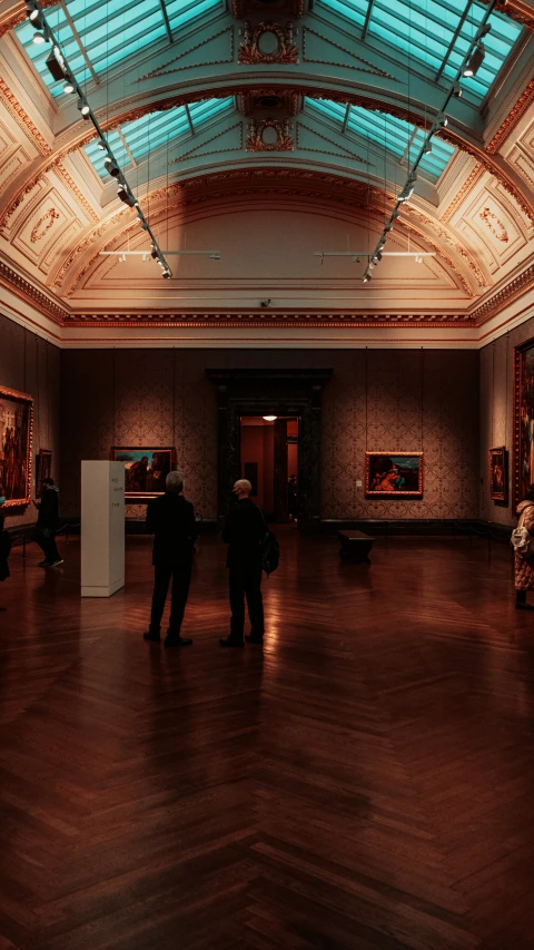 two men standing at the end of an art gallery