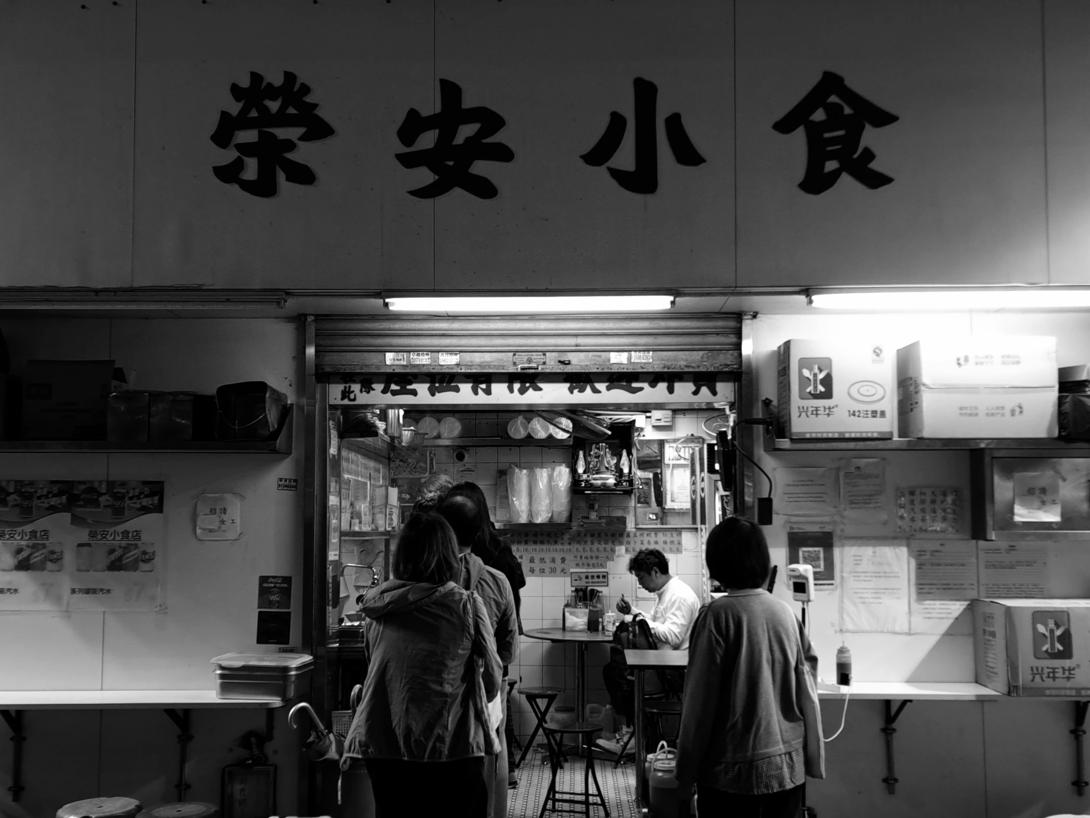 a group of people are standing outside of a restaurant